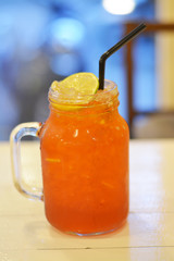 Lemon tea, cool big glass with clear glass backdrop.