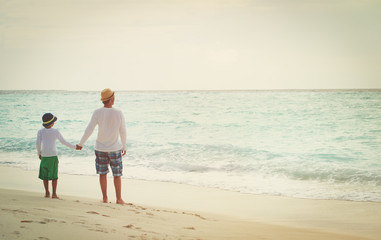 Fototapeta na wymiar father and little son walking on beach