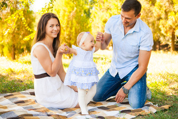 Happy young family spending time outdoor on a summer day, picnic in the park.