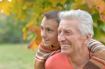 grandfather and grandson in autumnal park