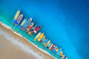 Washable wall murals Aerial view beach Boats. Aerial view of colorful boats in mediterranean sea in Oludeniz, Turkey. Beautiful summer seascape with ships, clear azure water and sandy beach at sunrise. Top view of yachts from flying drone