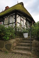 Fototapeta na wymiar malerisches Reetdachhaus mit Fachwerk in Sieseby, historisches und malerisches Dorf an der Schlei 