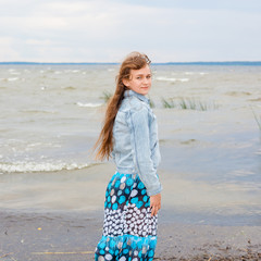 portrait of a beautiful young girl Goes into the distance. Teen girl On the beach. freedom and peace concept. Back view