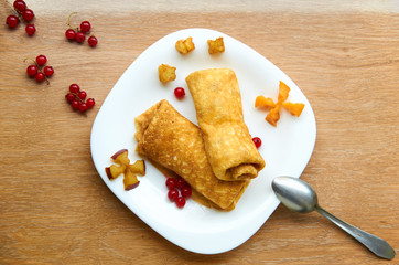 Crepes with  with cheese and fresh berries on white plate. Top view