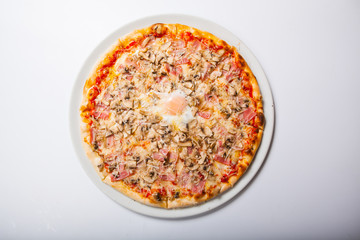 Italy pizza with egg yolk ham mushrooms on a white background