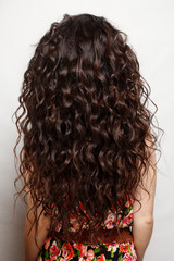 back of the woman with long brown curly hair