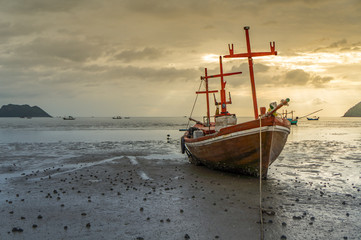 fishing boat on the beach with sea and sunrise background