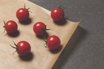 Fresh red cherry vine tomatos on a brown paper background