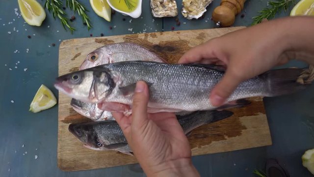 Someones hands Taking and showing raw fish breams