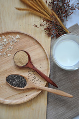 Glass of Milk with Amaranth and Chia Seed in Wooden Spoon