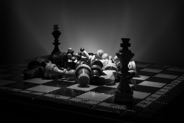 Black and white chess setup of king's shapes, and different pieces with dramatic lighting