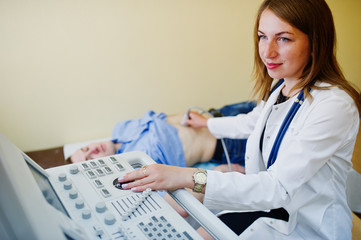 Beautiful young doctor doing diagnostic sonography on a patient.
