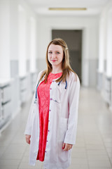 Portrait of a young attractive doctor in white coat with stethoscope posing in the hospital.