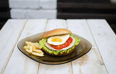 Hamburger with fresh lettuce and eggs. French fry