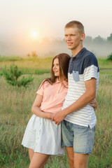 Young romantic loving couple stands in the middle of the field