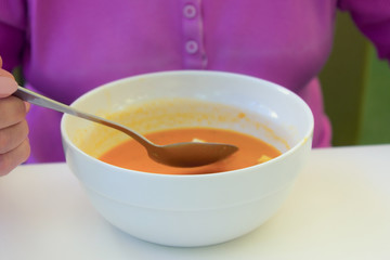 A plate of pumpkin soup on the table. Spoon in  plate