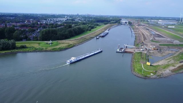 Aerial of tanker barge ship on river the Lek near Vianen in the Netherlands entering the locks – 4K