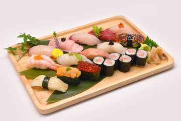 Mixed sushi set in brown wooden tray on white background