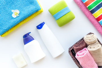 Bath accessories. Towels, soap, shampoo, washclothes on white background top view copyspace