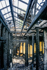 Burnt interiors of house after fire.Charred ceilings and supports. Burned wooden walls