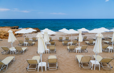 Sandy beach with parasols and beach loungers Crete