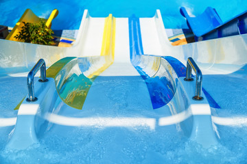 View from top on colorful plastic water-slide in swimming pool. Blur aperture