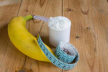 Whey protein with measuring tape and banana
