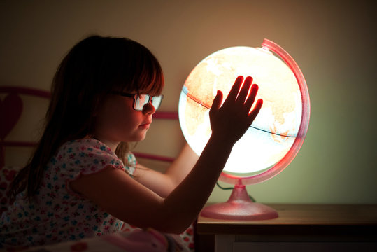 Side view of a girl holding illuminated globe