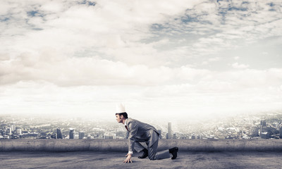 King businessman in elegant suit running on building roof and bu