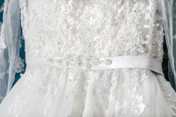 Part of white luxury bridal dress with shining rhinestones. of the bride. Wedding bodice. Close-up