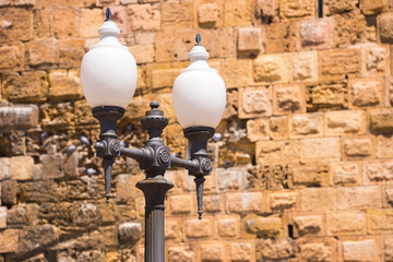 Beautiful street lamp on the background of a stone wall.