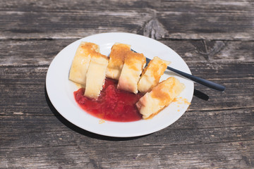 Traditional Slovene Struklji with strawberry jam an white plate,