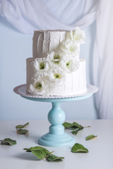 White bunk wedding cake decorated with flowers