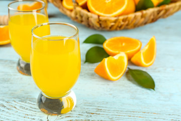 Glass of fresh orange juice on wooden background