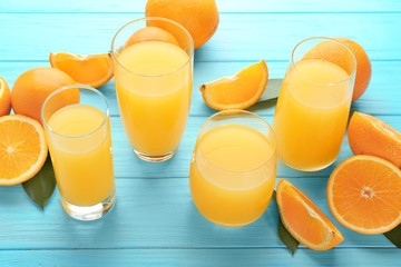 Glasses of fresh orange juice on wooden background