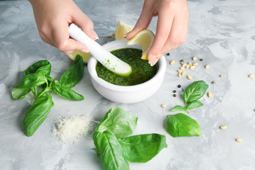 Young woman preparing delicious sauce on table