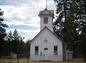 Old white, clapboard church on country road in rural Montana