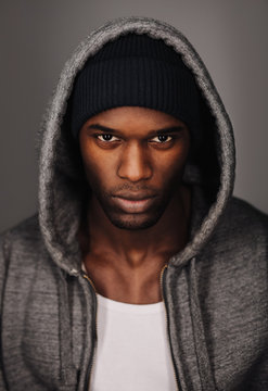 Black man in urban style looking tough on grey background