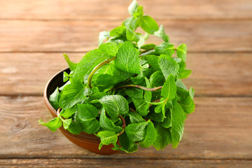 Bowl with lemon balm on table
