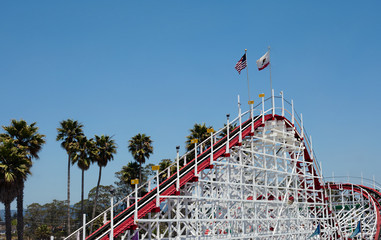Wooden roller coaster with blue sky and palm trees