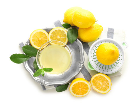 Composition with squeezer, lemons and juice on white background