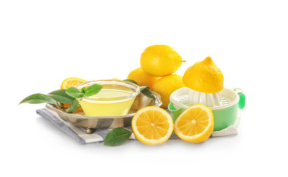 Composition with squeezer, lemons and juice on white background