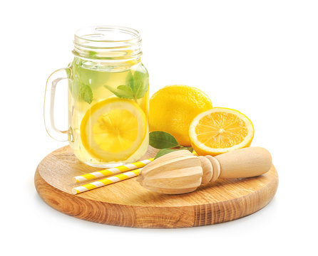 Wooden board with juicer and lemonade on white background