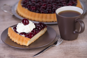 Kirschtorte mit Sahne und Tasse Kaffee