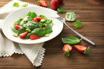 Tasty salad with spinach and strawberry on plate