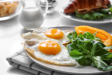 Tasty breakfast with fried eggs on table