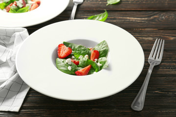 Tasty salad with spinach and strawberry on plate