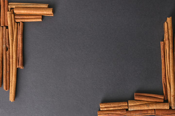 Frame made of cinnamon sticks on dark background