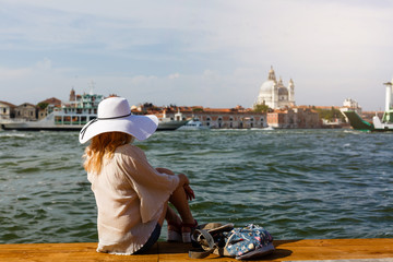 girl sitting on a pier near the canal at the venice. Italy