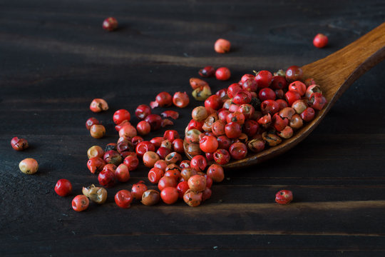 Wooden spoon with spices on dark background. Red pepper in wooden spoon. Colorful natural additives.
